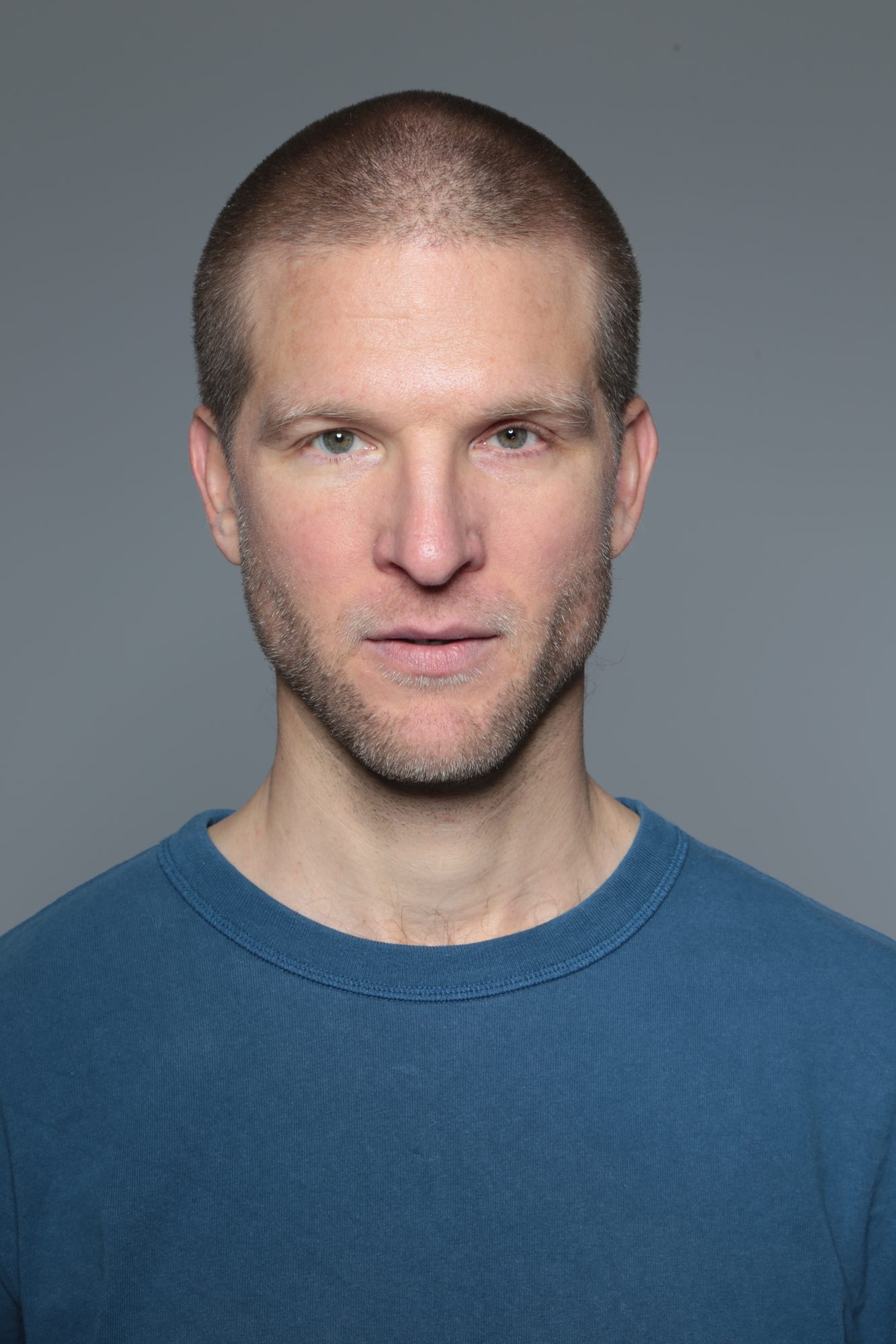 Portrait de face, t-shirt bleu, fond gris