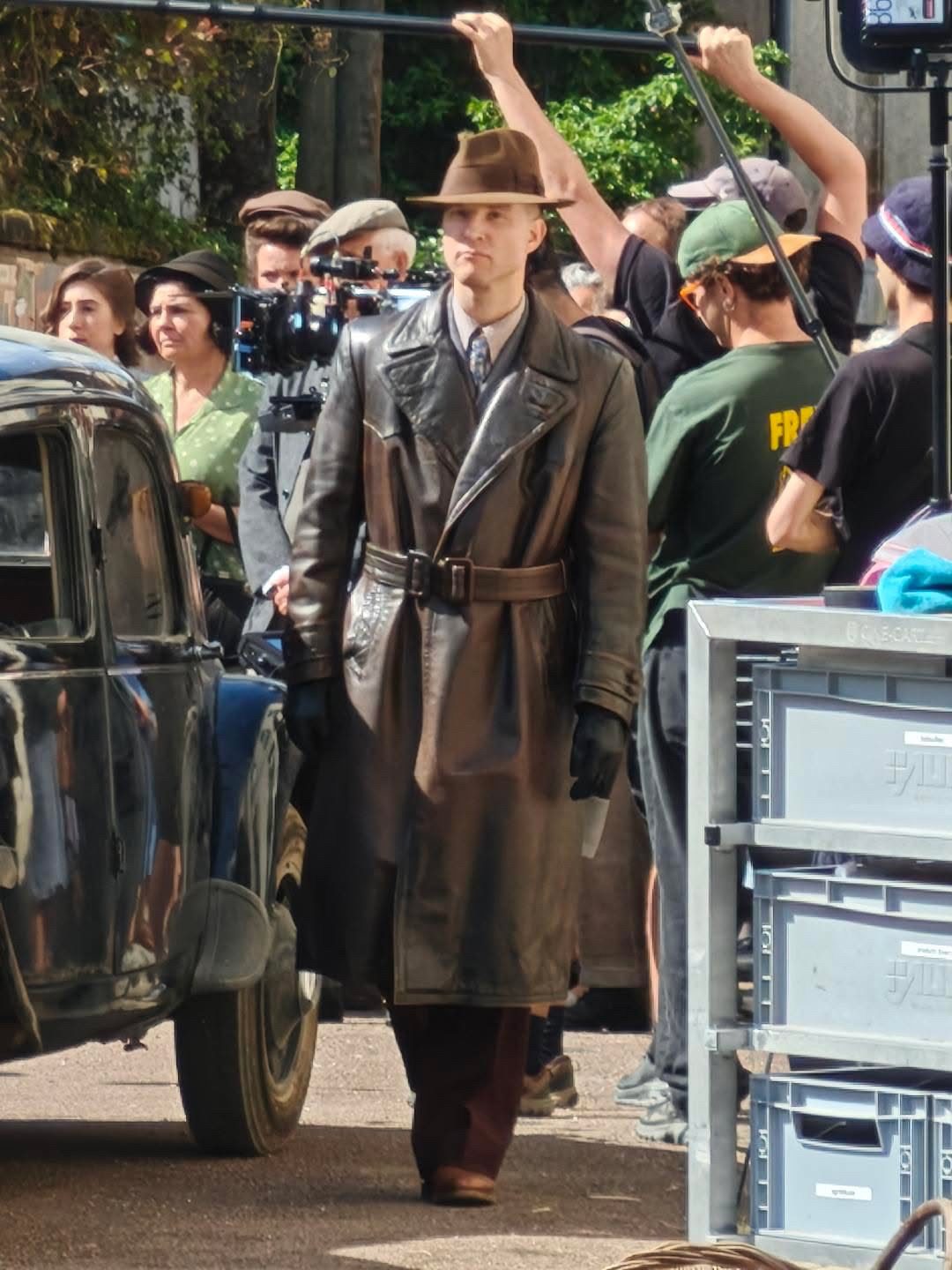 Sur un tournage, en manteau de cuir, au milieu de l'équipe